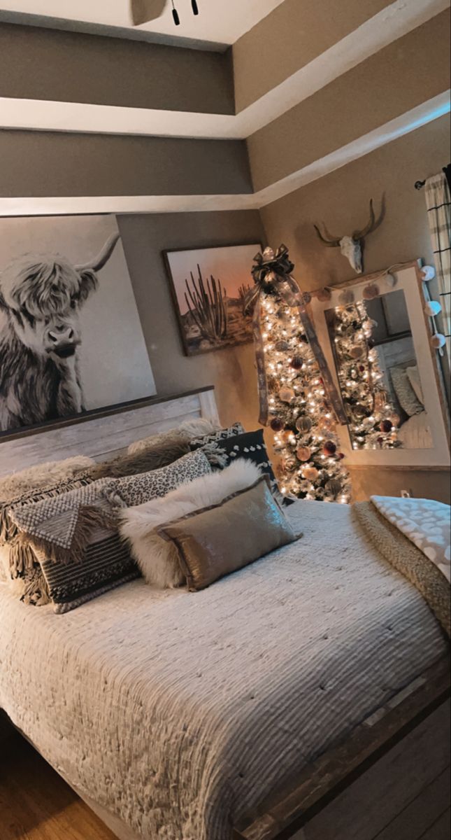 a bedroom decorated for christmas with lights on the headboard and pictures above the bed