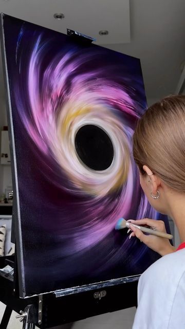 a woman is working on an abstract painting