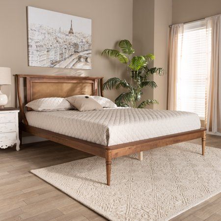 a bed sitting on top of a wooden floor next to a window