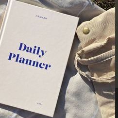 a book sitting on top of a bed next to a pair of pants and shoes