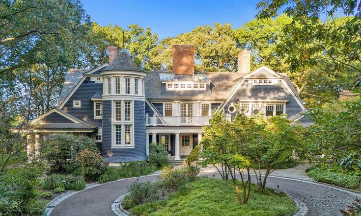 a large blue house surrounded by trees and bushes