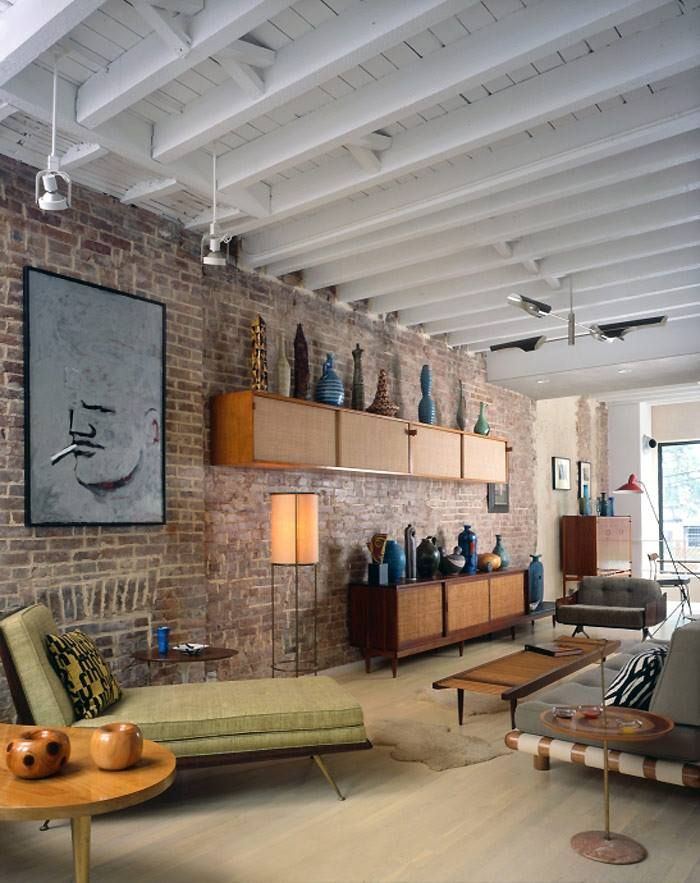 a living room filled with furniture and a brick wall