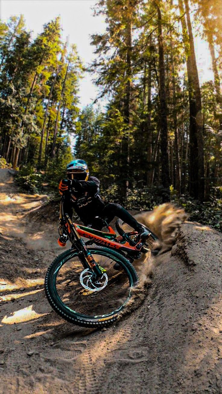 a man riding a dirt bike on top of a forest