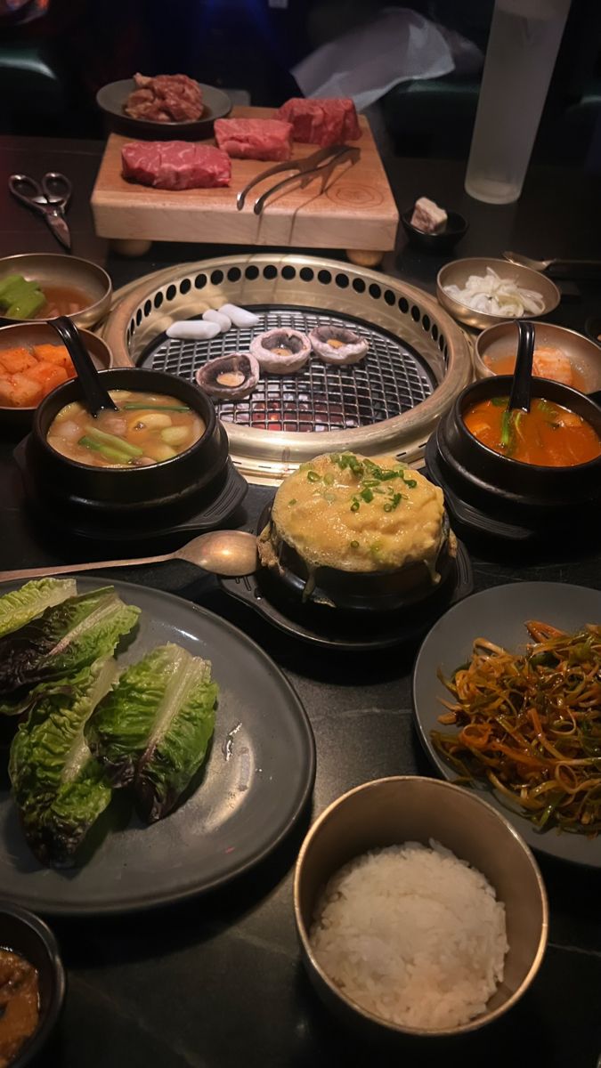 a table topped with lots of different types of food and bowls filled with soups