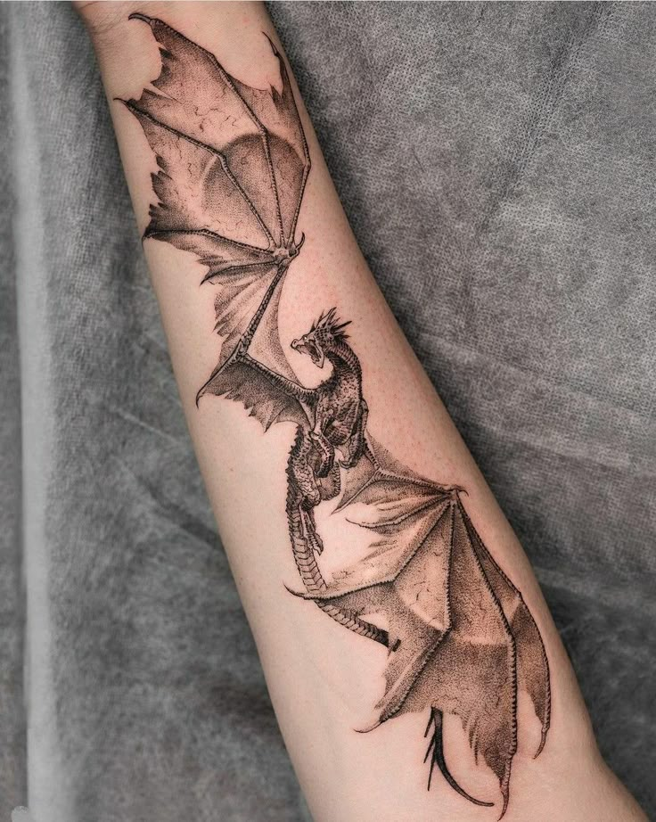 a black and white photo of a dragon on the arm