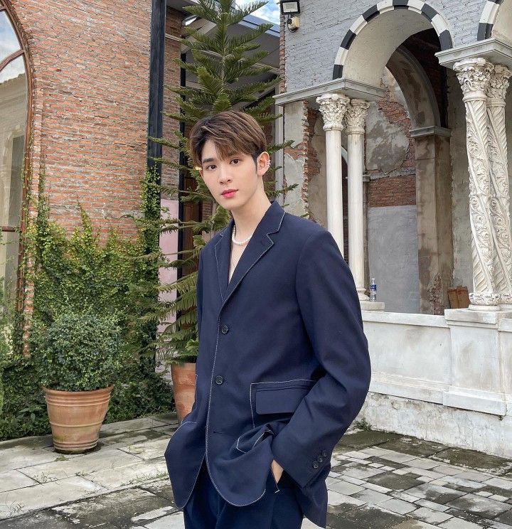 a young man standing in front of a building