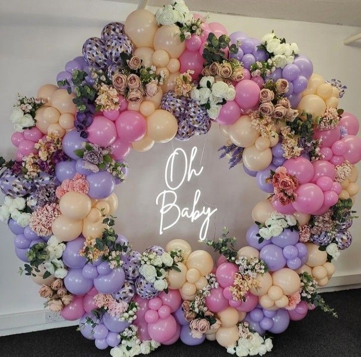 a wreath made out of balloons and flowers with the words oh baby written on it