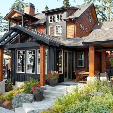 a large house with lots of windows and plants in the front yard, along with steps leading up to it