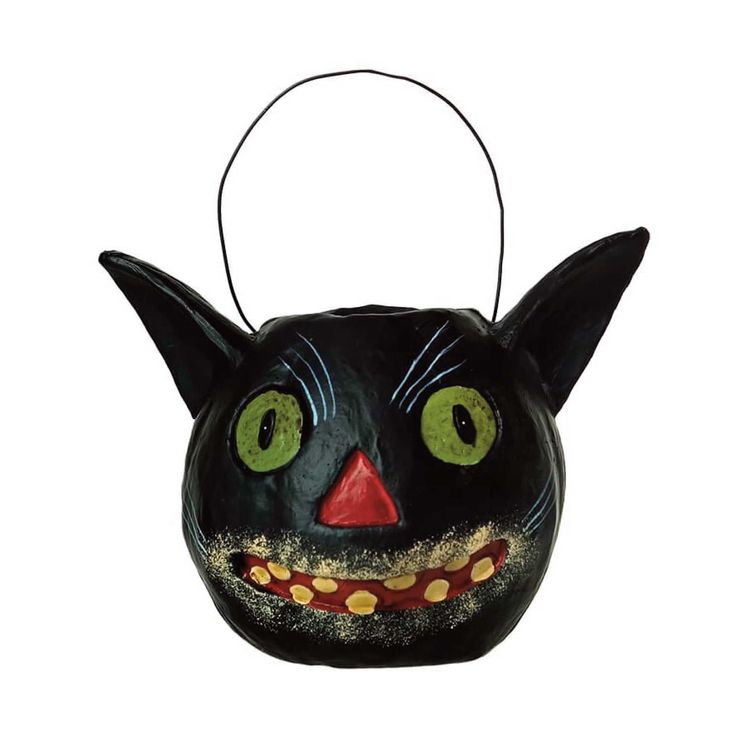 a black cat mask with green eyes and fangs on it's face is hanging from a wire