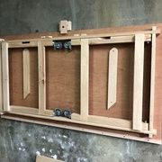 an unfinished wooden cabinet hanging on the wall