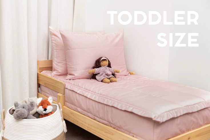 a bed with pink sheets and pillows next to a stuffed animal