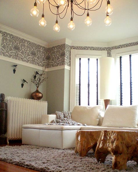 a living room filled with furniture and a chandelier hanging from the ceiling above it