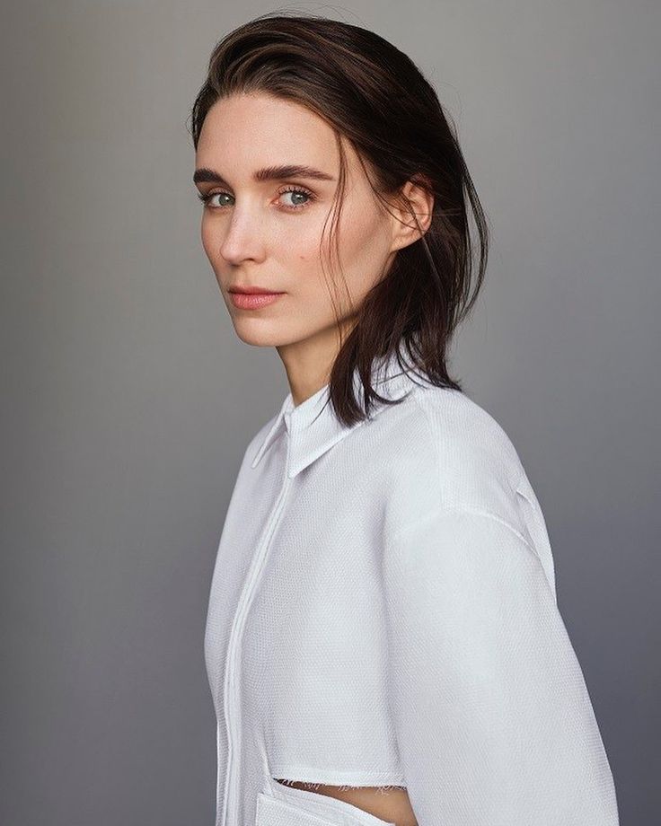 a woman with dark hair wearing a white shirt