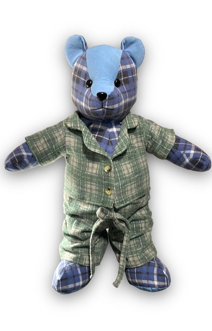 a blue teddy bear wearing a green plaid suit and tie with one hand on his hip