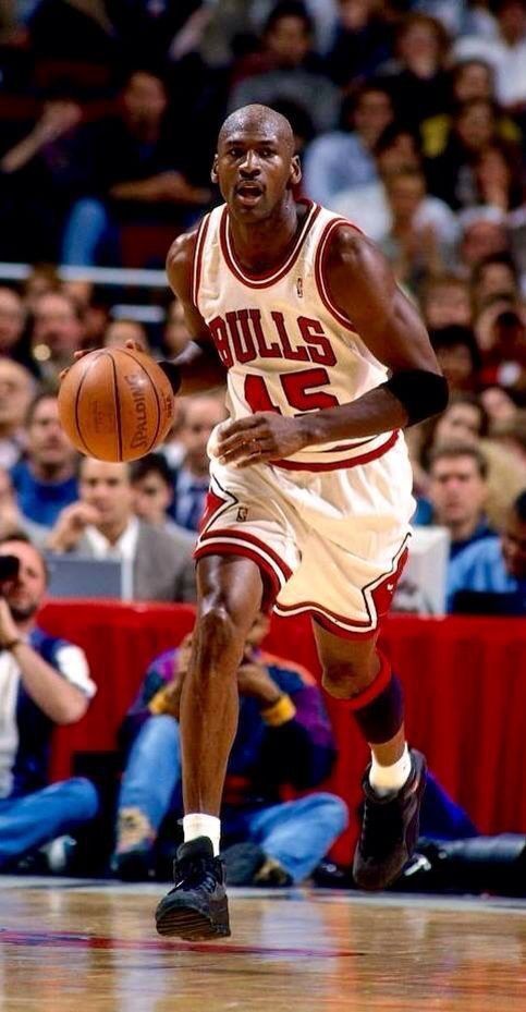 a basketball player dribbling the ball during a game in front of an audience