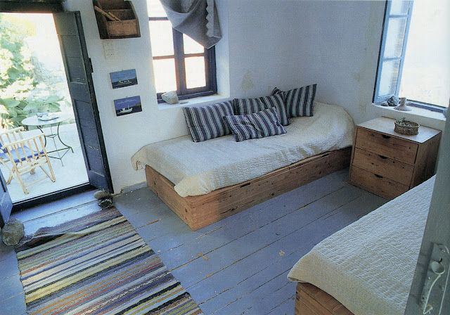 a room with two beds and a rug on the floor in front of a sliding glass door