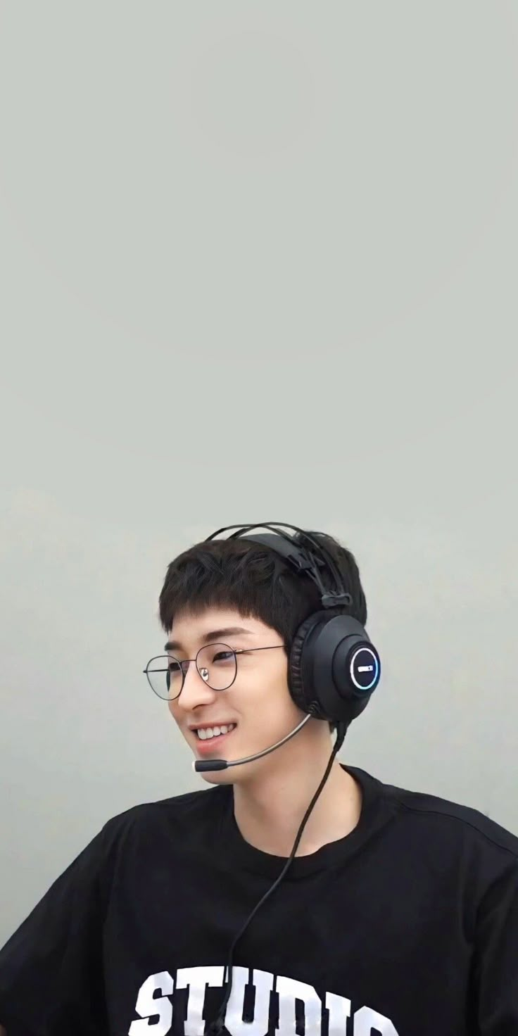 a young man wearing headphones sitting in front of a laptop computer