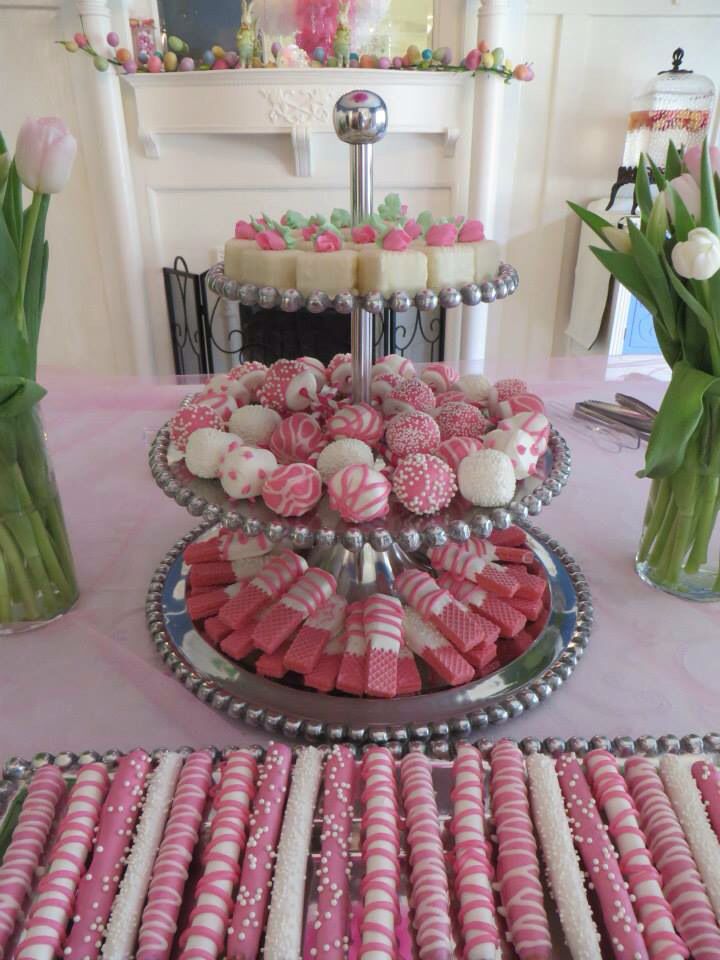 pink and white desserts are displayed on a table