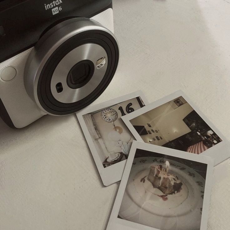 three polaroid pictures sitting on top of a table next to a camera