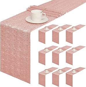 a pink table runner with place mats and napkins on it, next to a coffee cup