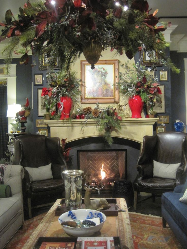 a living room filled with furniture and a fire place under a christmas wreath on the wall