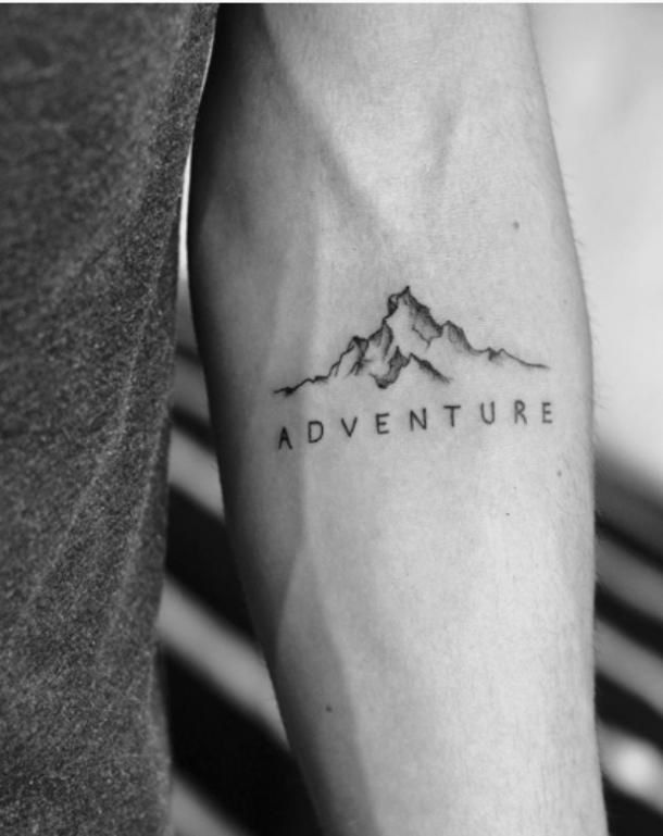 a man's arm with the words adventure on it and mountains in black ink