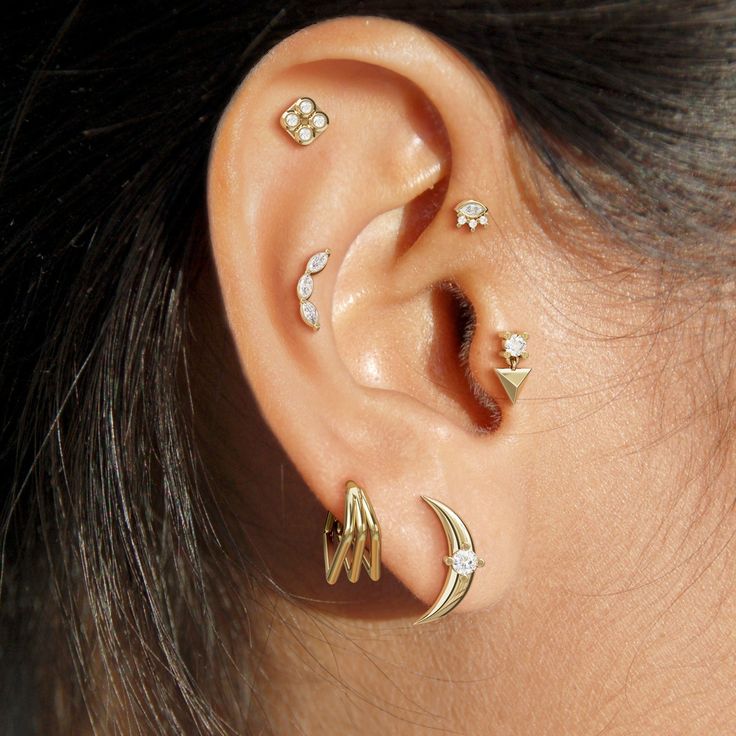 a close up of a person's ear with three different piercings on it