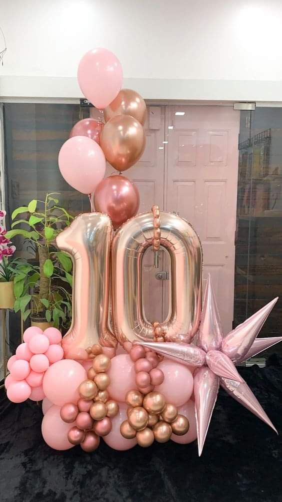 the balloon number 10 is surrounded by balloons and starbursts in front of a door