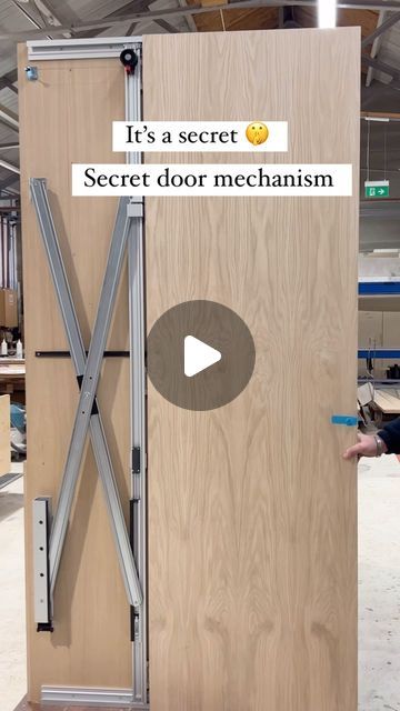 a man standing in front of a wooden door that says it's a secret secret door mechanism