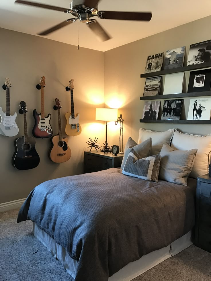 a bedroom with guitars hanging on the wall and a bed in front of it,