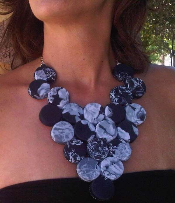 a woman wearing a black and white flowered necklace with blue flowers on the front