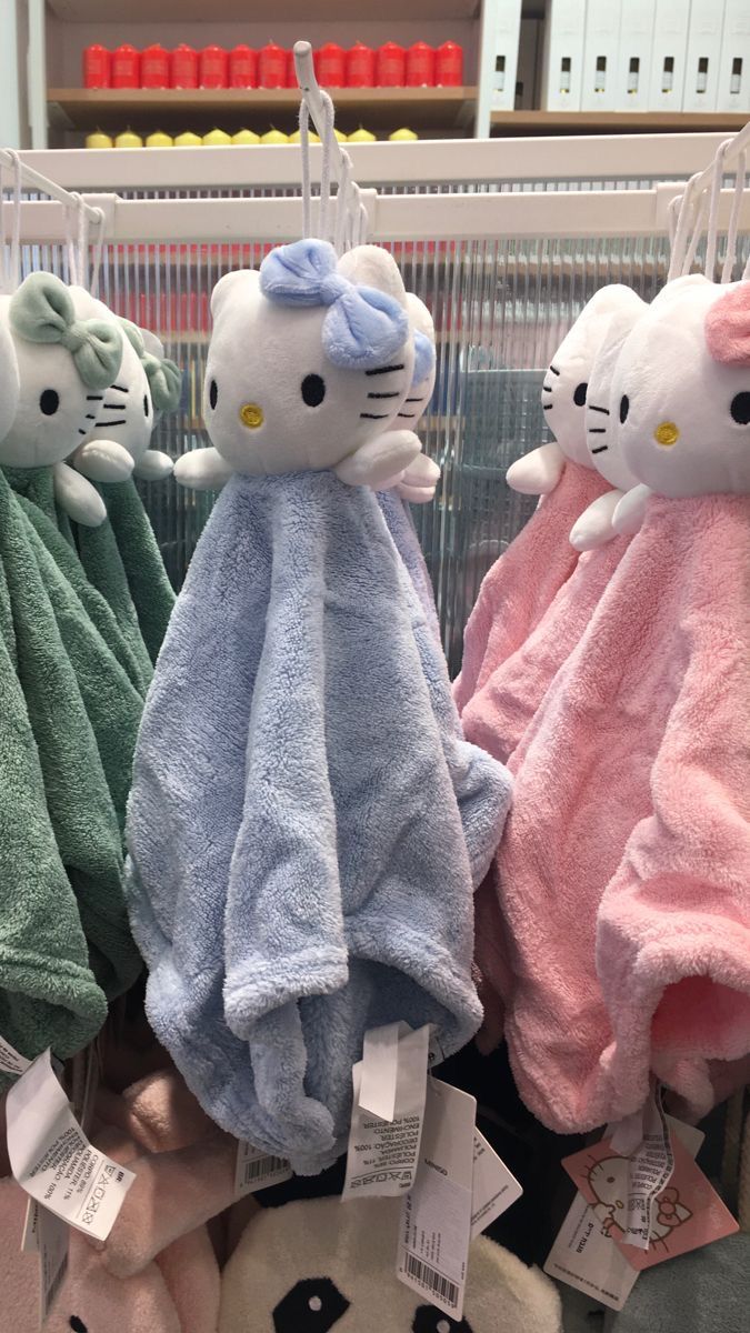 hello kitty towels are hanging on the rack in a store with other plush animal ones