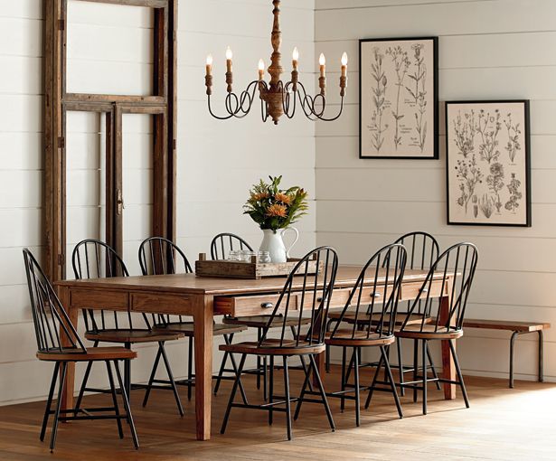 a dining room table with chairs and a chandelier hanging from the ceiling above it