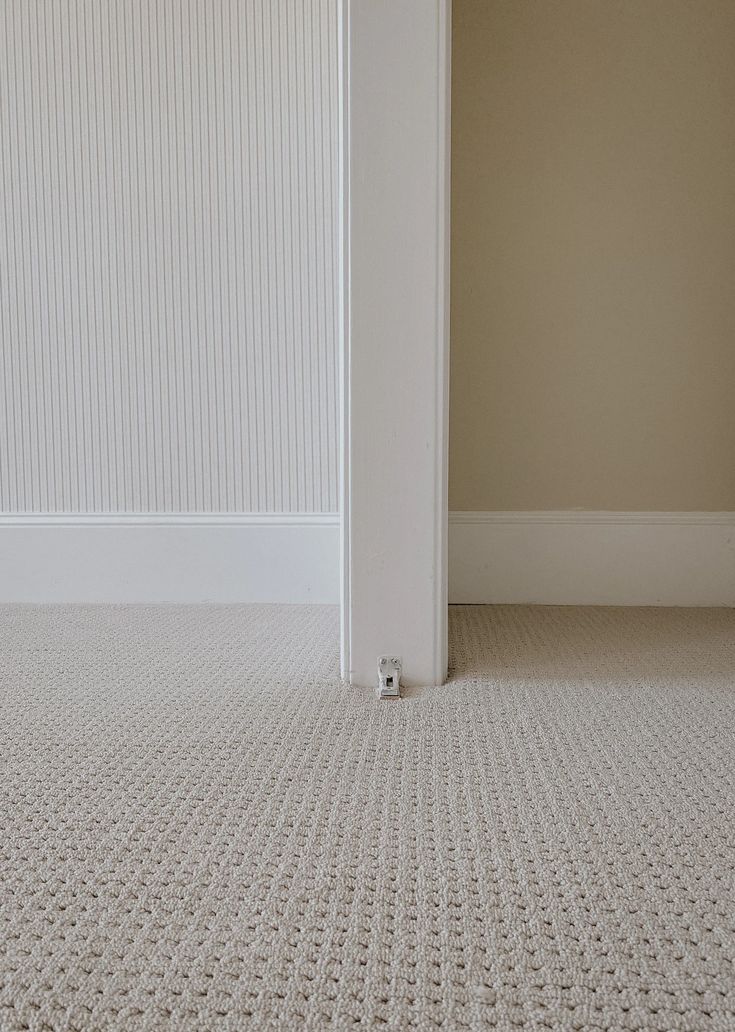 an empty room with white walls and carpet