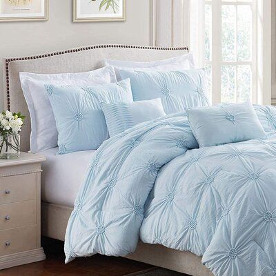 a bed with blue comforters and pillows in a bedroom