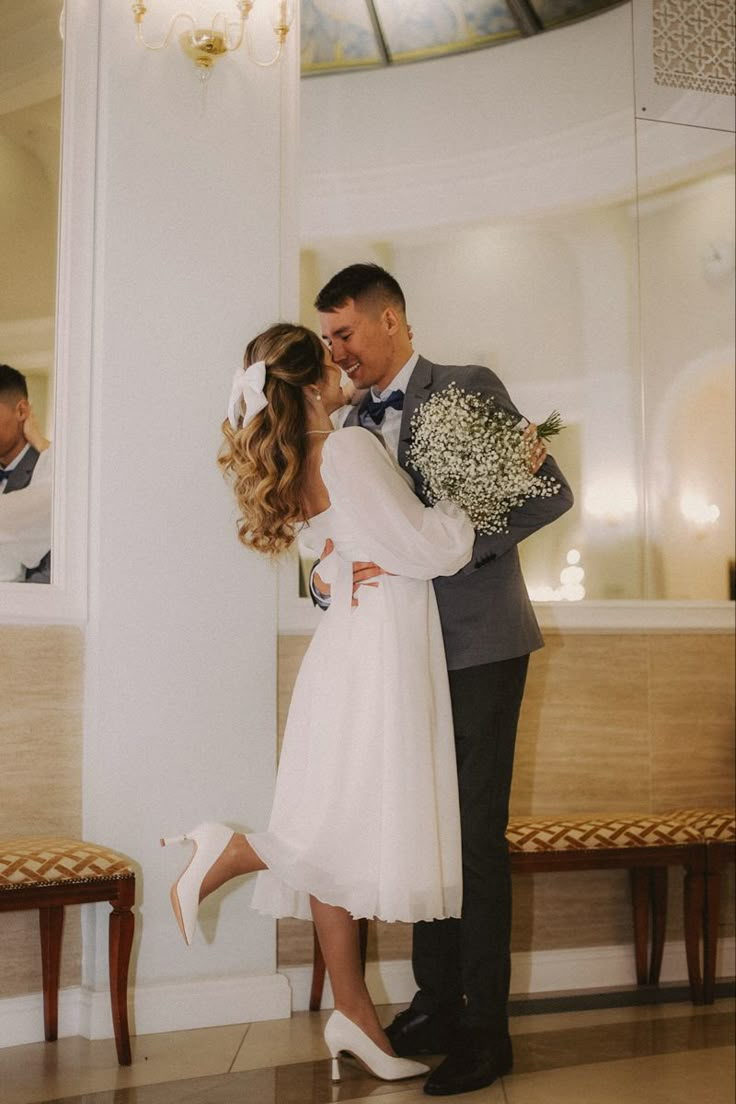 a bride and groom are kissing in front of a mirror at their wedding reception venue