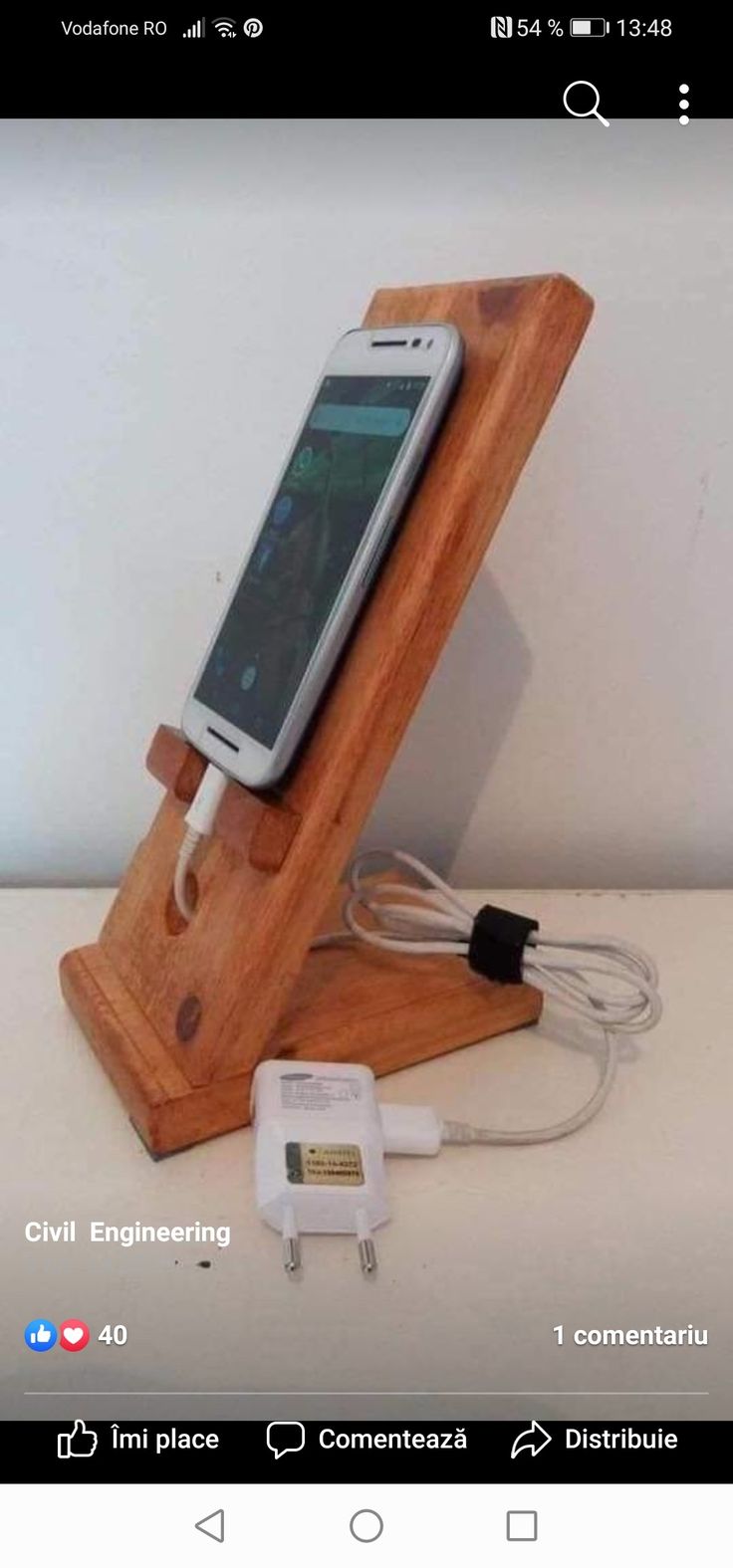 a cell phone and charger on a wooden stand