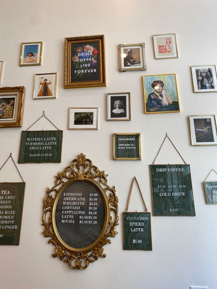 a wall with many different framed pictures on it and hanging from the side, along with an ornate gold frame