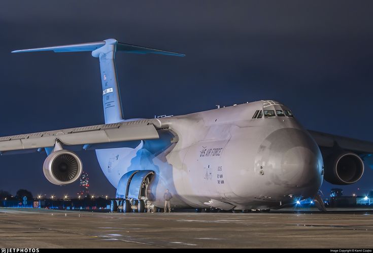 an airplane sitting on the tarmac at night