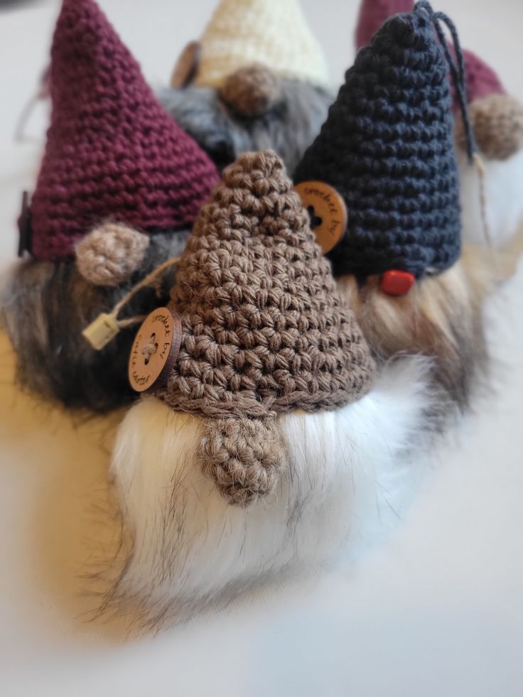 three small crocheted gnome hats on top of a stuffed animal's head