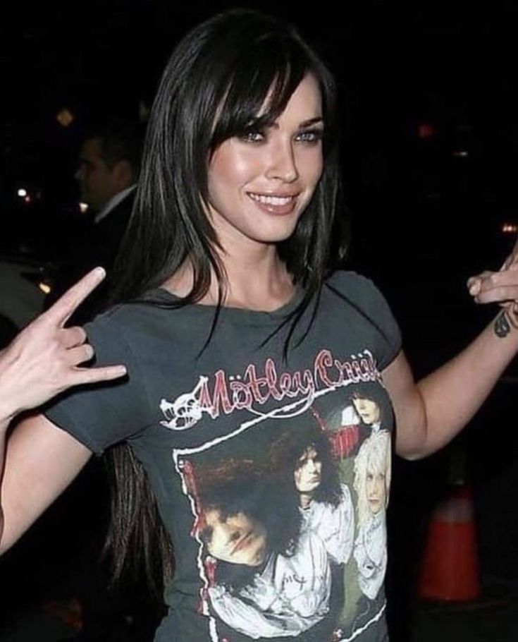 a woman with her hands in the air and wearing a shirt that has an image on it