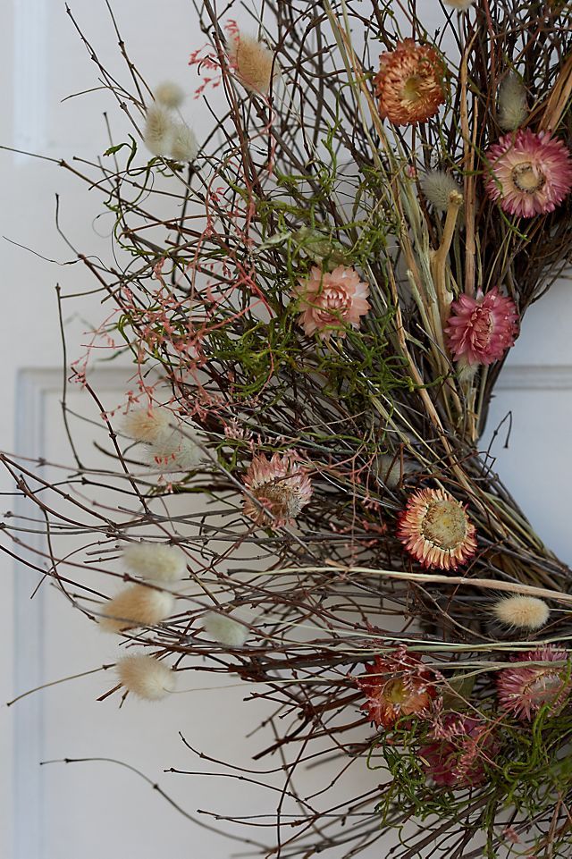 a wreath with dried flowers on the front door