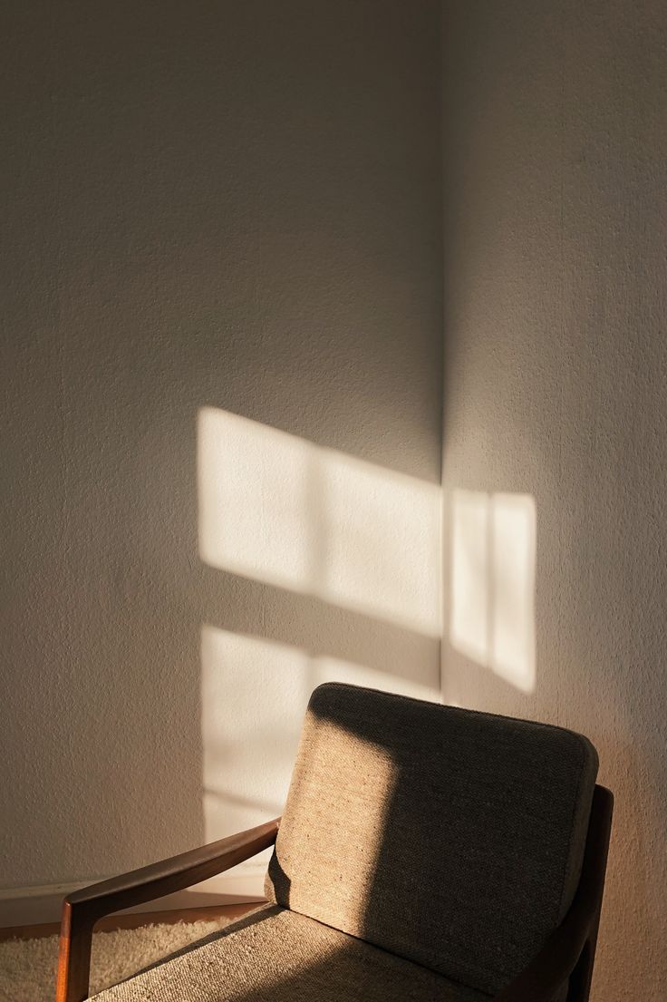 a chair sitting in front of a window with the sun shining on it's side