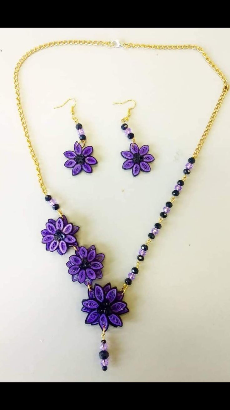 a necklace and earring set with purple flowers