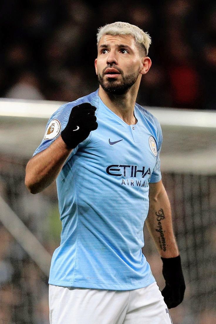 a soccer player is looking up at the ball in front of him and holding his hand out