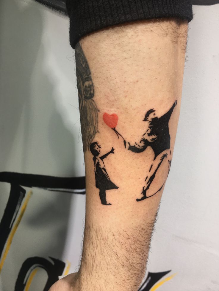 a man with a tattoo on his arm holding a heart