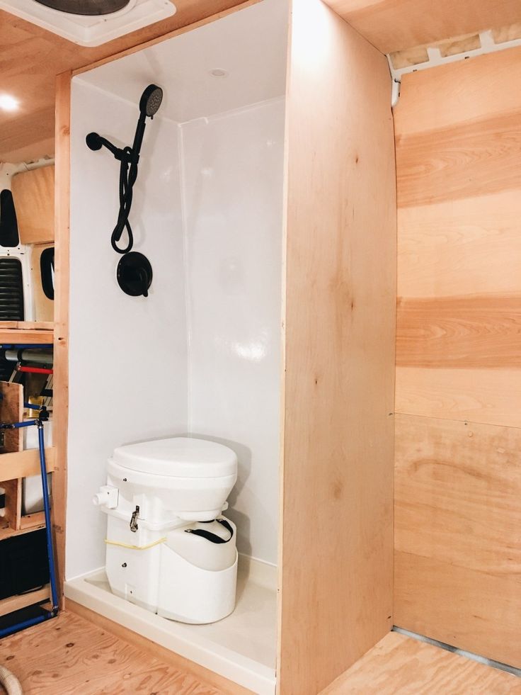 there is a white toilet in the corner of this room with wood paneling on the walls