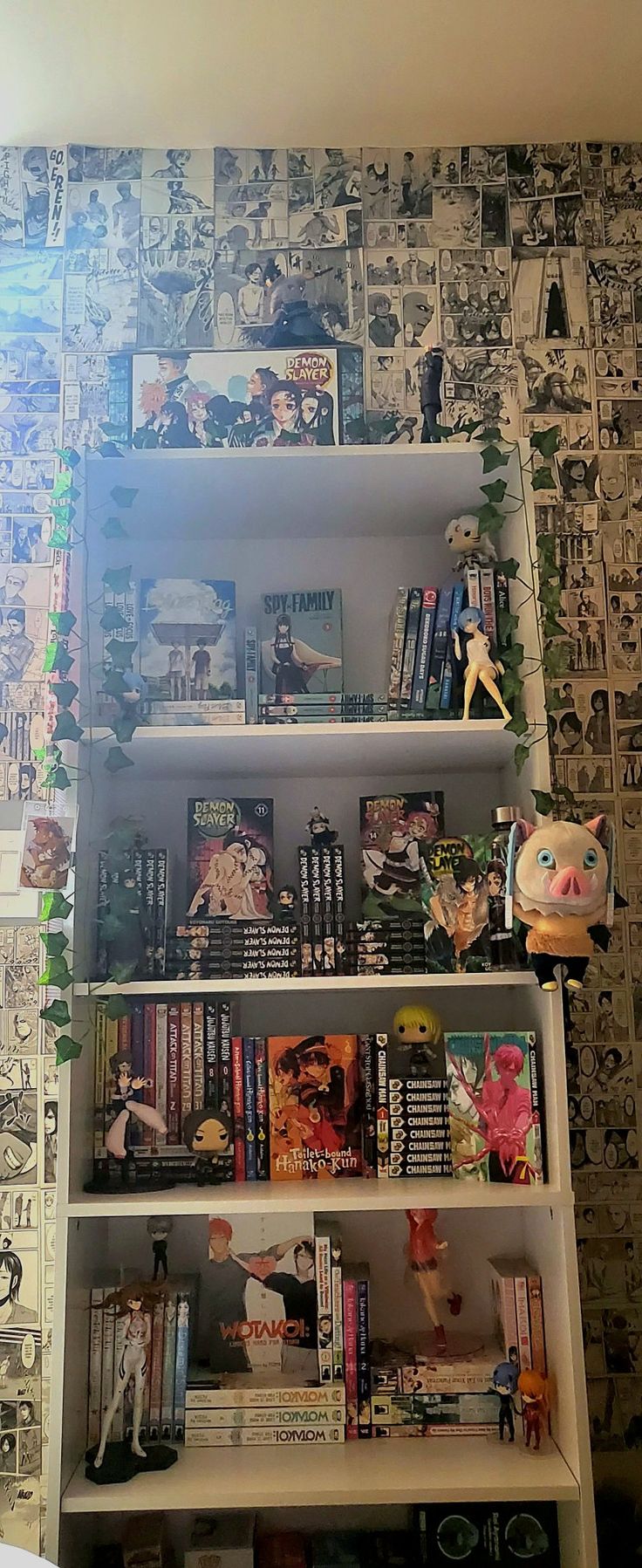 a bookshelf filled with lots of books next to a wall covered in comics