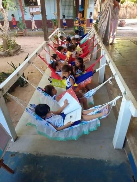 a group of children sitting in hammocks on a porch next to each other