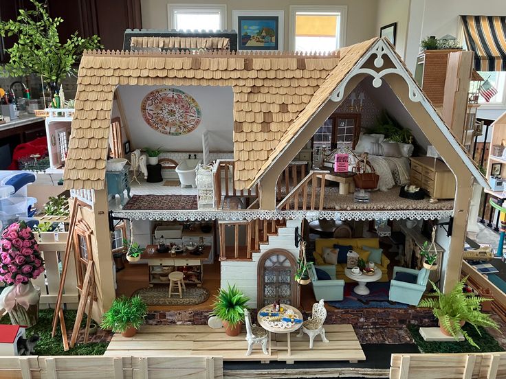 a doll house made out of wood with furniture and accessories in the front yard area